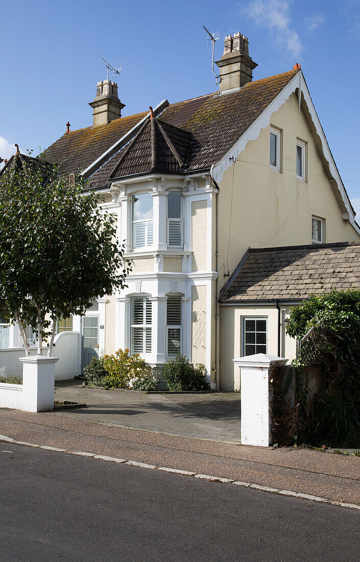 Gelb gestrichene Fassade einer Doppelhaushälfte in Shoreham by Sea West Sussex England UK
