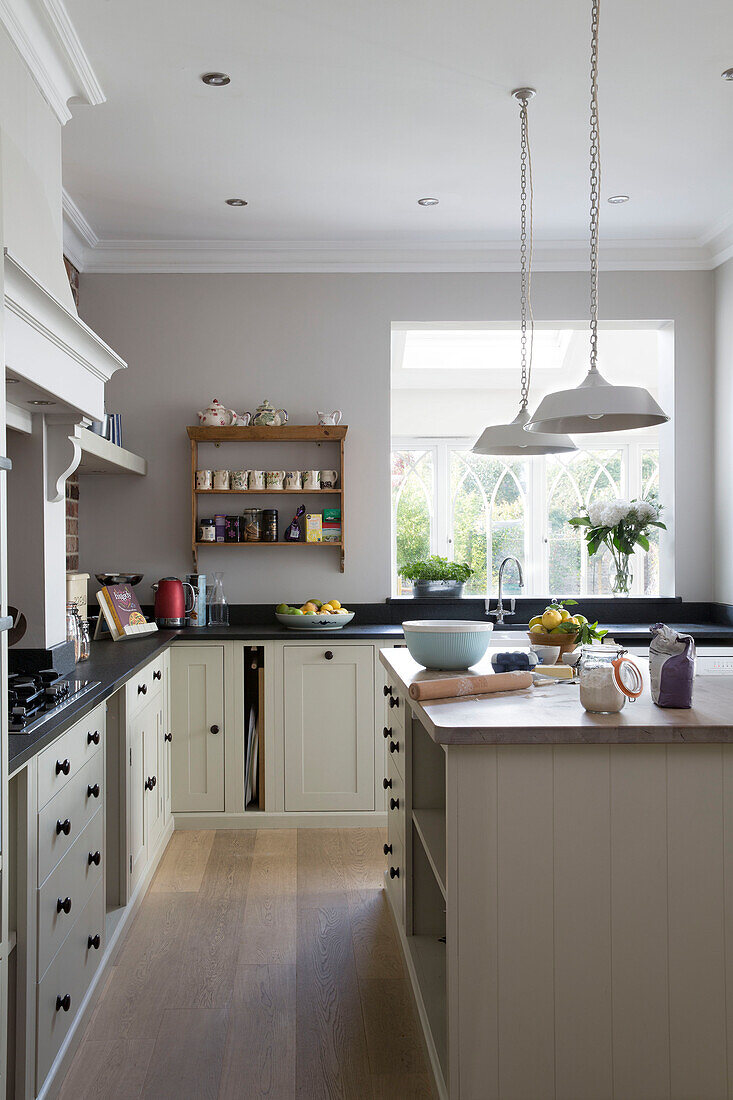 Hängeleuchten über einer Kücheninsel mit Backzutaten in einem Haus in Shoreham by Sea West Susses England UK