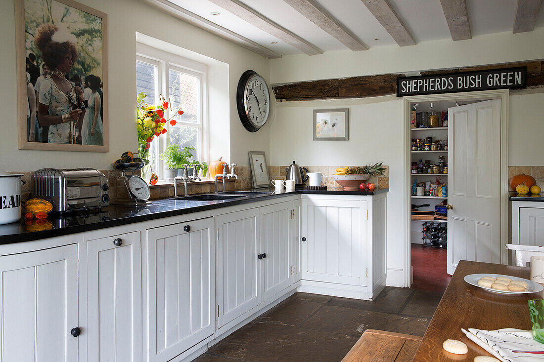 Weiße Einbauküche im Landhausstil mit Blick in die Speisekammer in einem Londoner Haus, England, UK