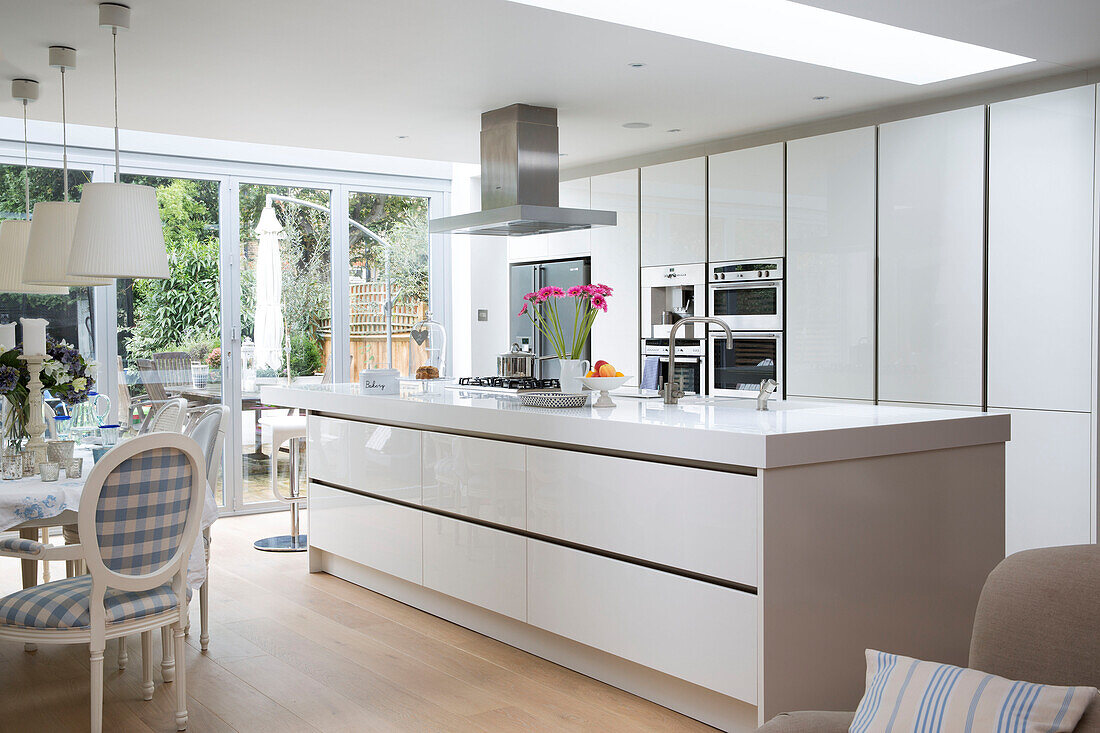 Open plan fitted kitchen with extractor above island unit in Hertfordshire home,  England,  UK