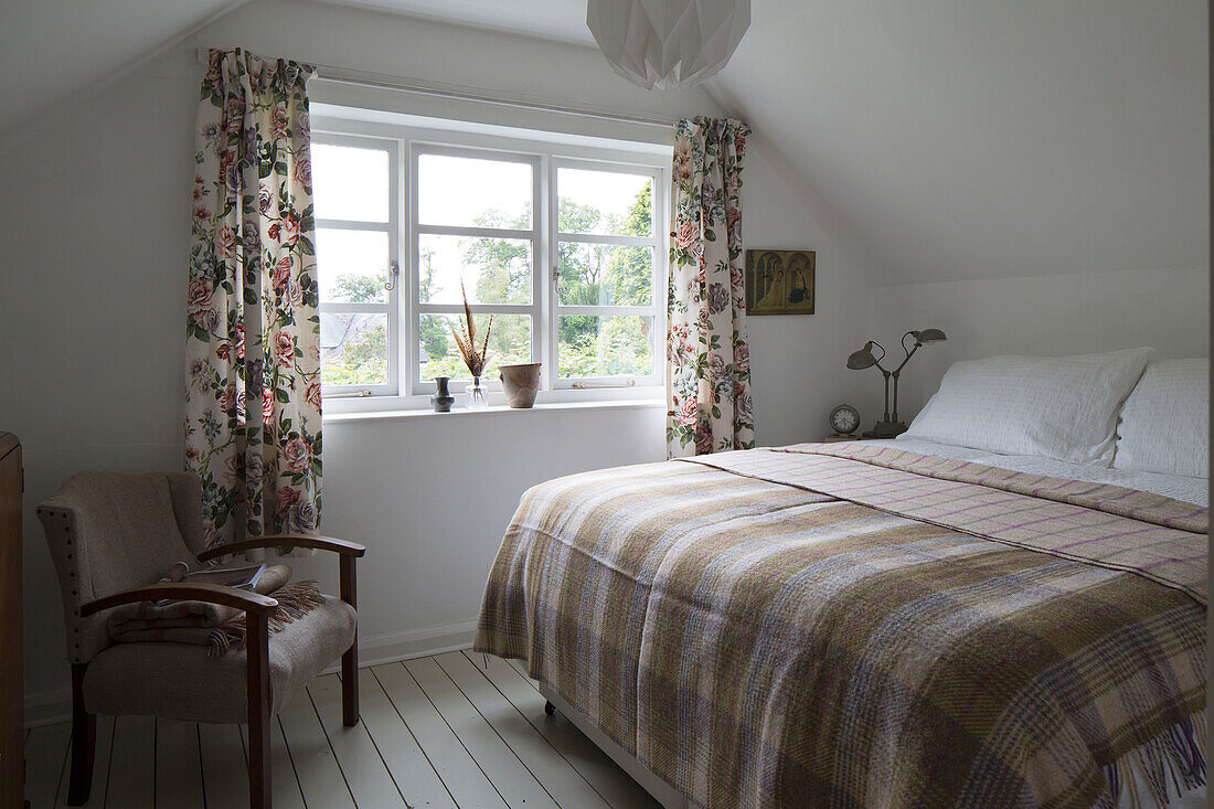 Geblümte Vorhänge am Fenster mit Doppelbett in Presteigne Cottage in Wales UK