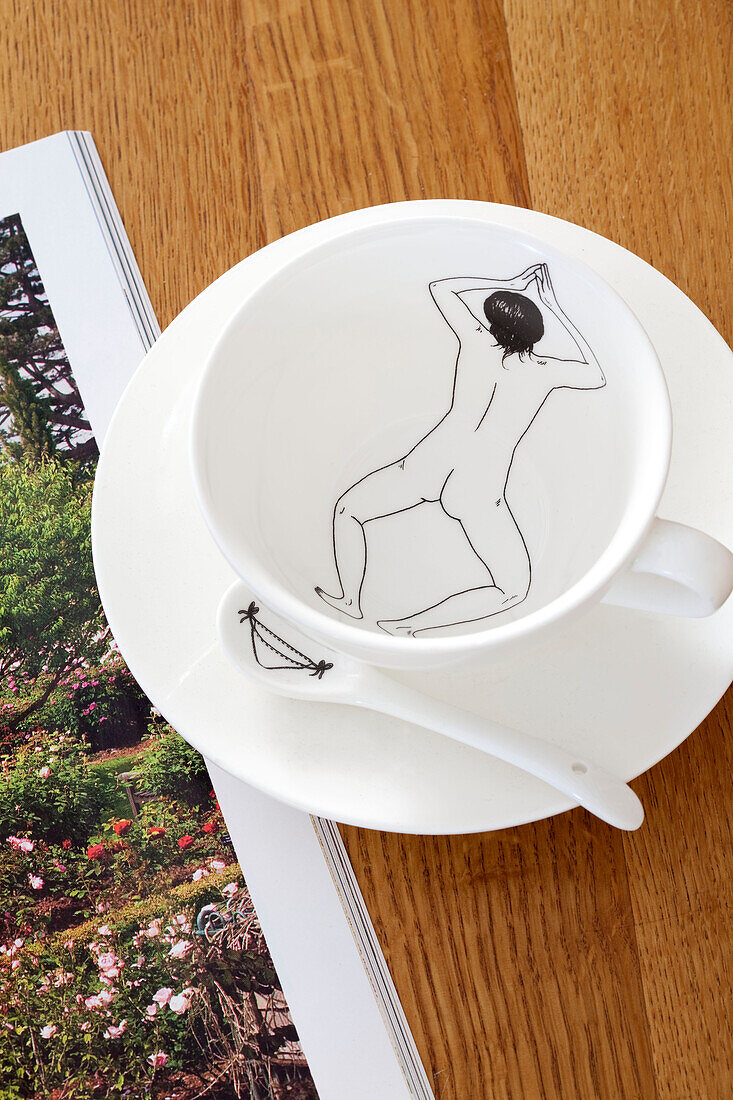 Naked swimmer outline on bowl with plate on wooden table in London townhouse, England, UK