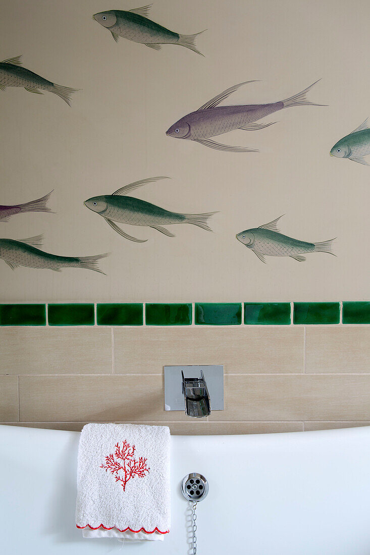 Fische schwimmen über einer Keramikbadewanne in einem Haus in London, England, UK