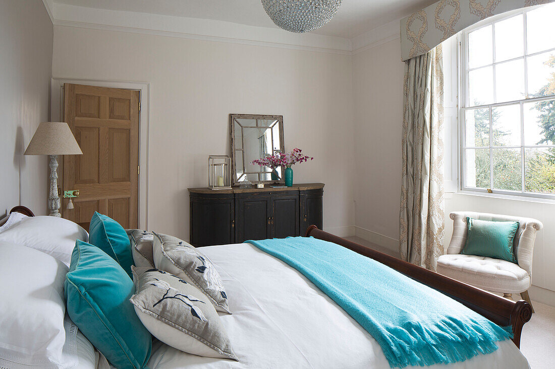 Türkisfarbene Kissen und Decke auf einem Doppelbett in einem Haus in Surrey, England, UK
