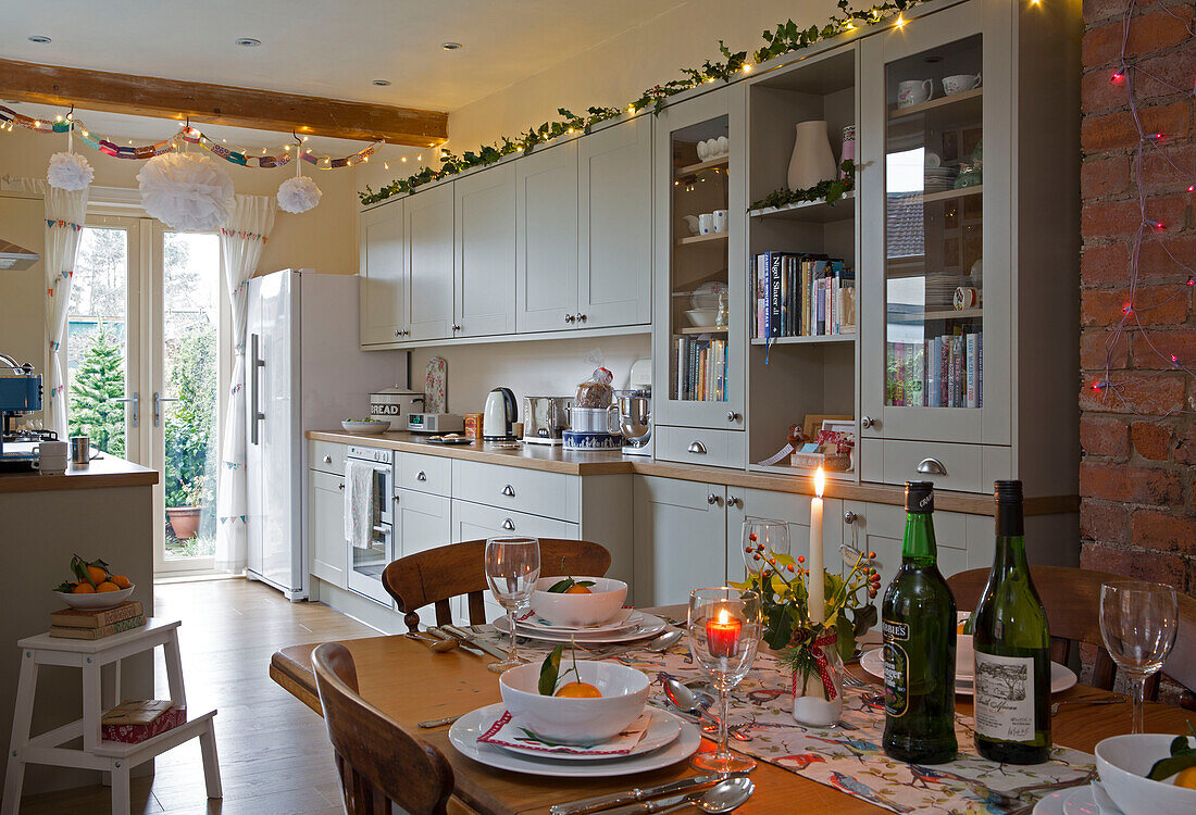 Lichterketten und brennende Kerze in offener Küche Esszimmer zu Weihnachten in Dronfield home Derbyshire England UK