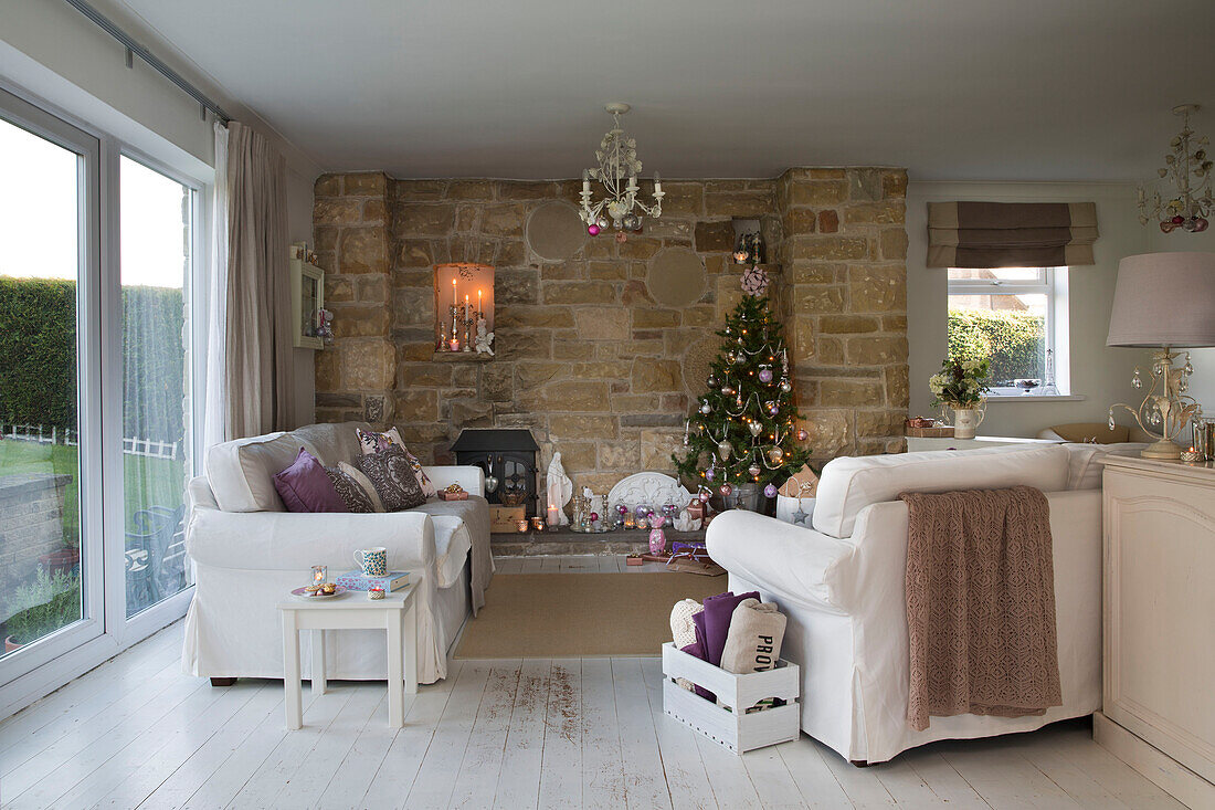 Weihnachtsbaum in Steinnische mit weißen Sofas im Wohnzimmer von Laughton Sheffield UK