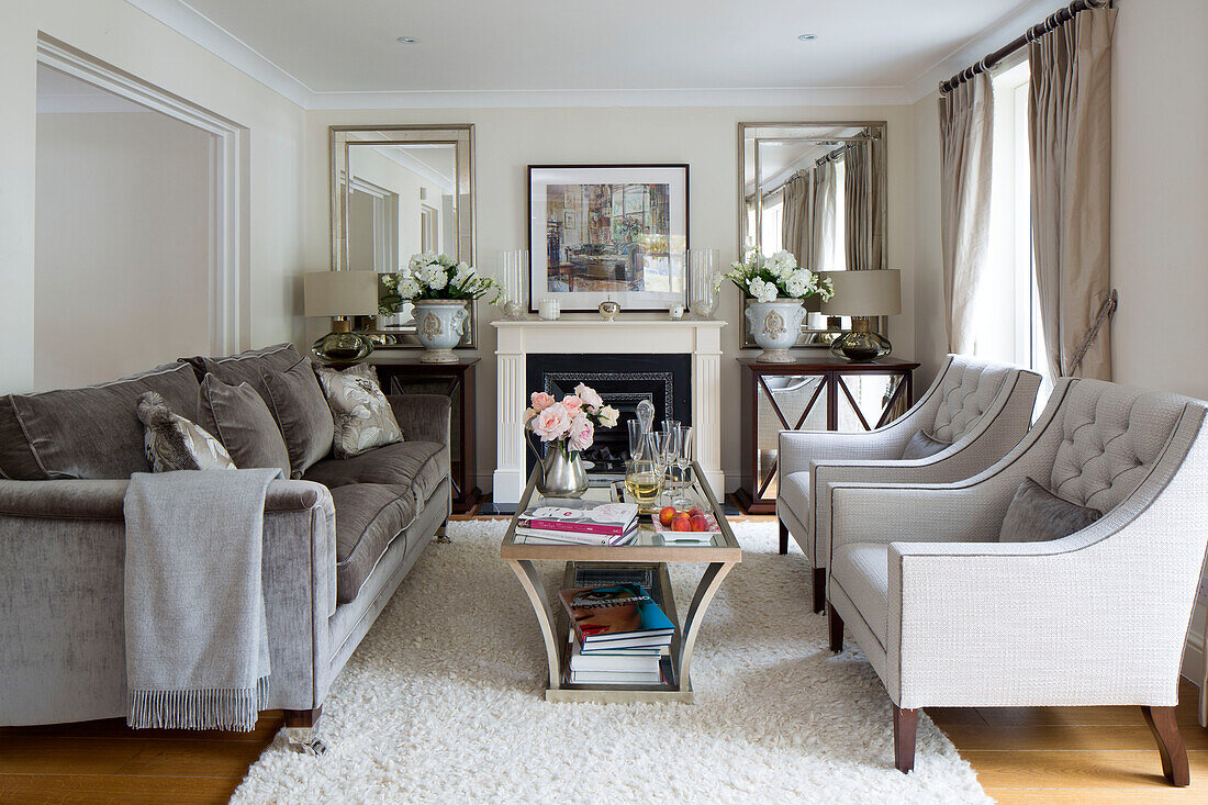 Graues Sofa mit zwei gepolsterten Sesseln im klassischen Wohnzimmer eines Londoner Hauses England UK