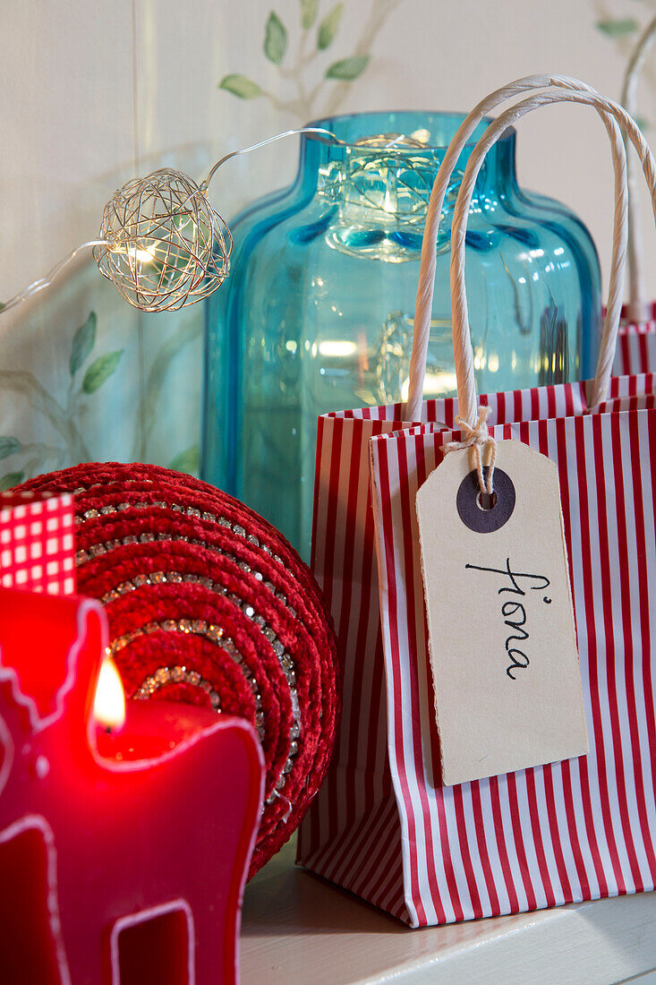 Etikett auf gestreifter Geschenktüte mit Beleuchtung und blauem Glas im Haus in Sussex England UK