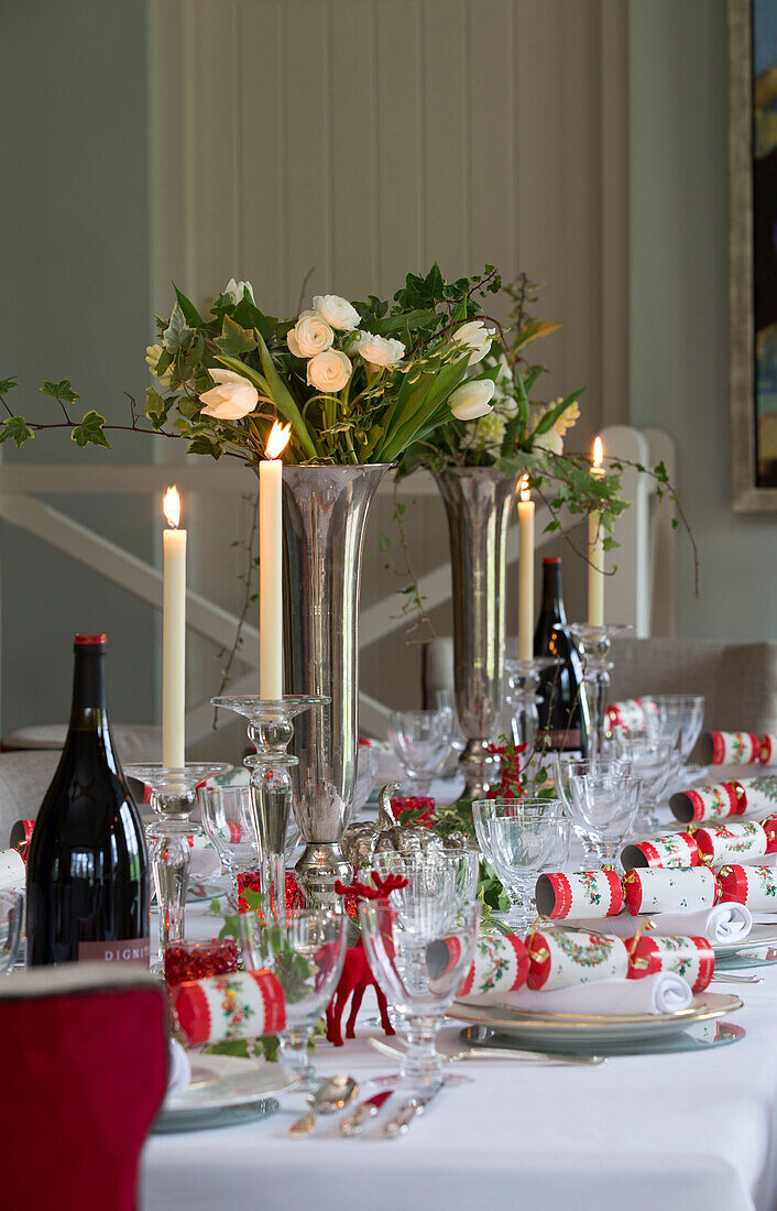 Kerzen und weiße Rosen auf dem Esstisch in einem Haus in Lymington, Hampshire UK