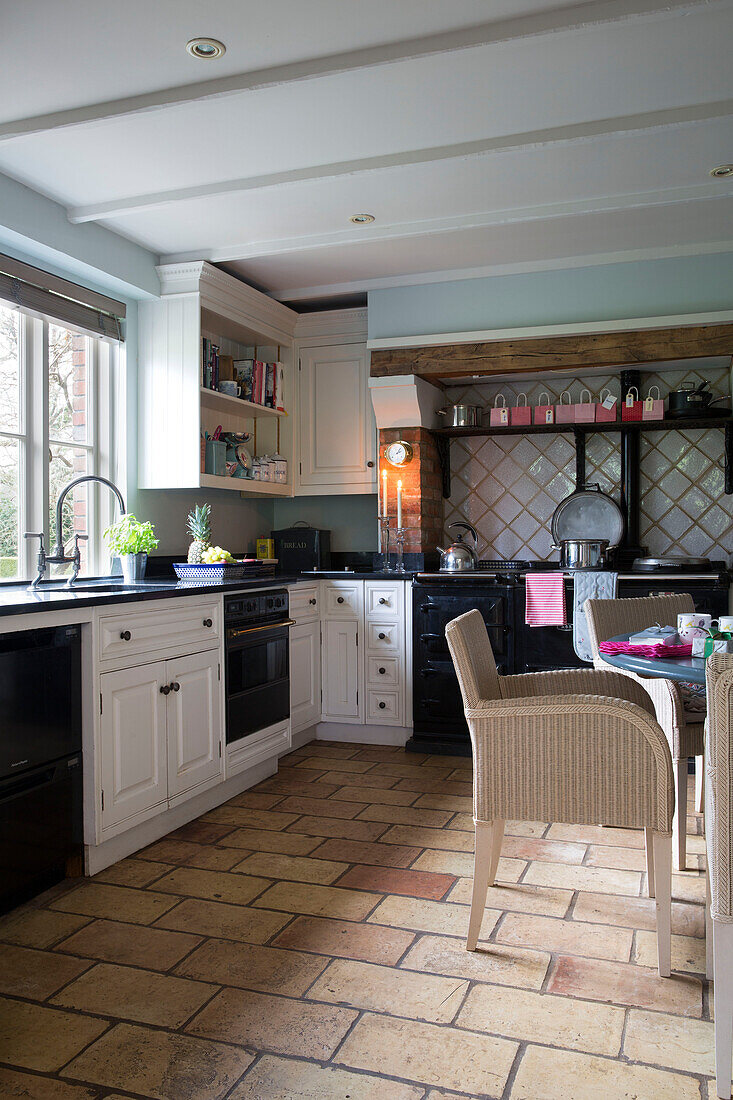 Schwarz-weiße Einbauküche mit Steinboden in einem Haus in Lymington, Hampshire, Großbritannien