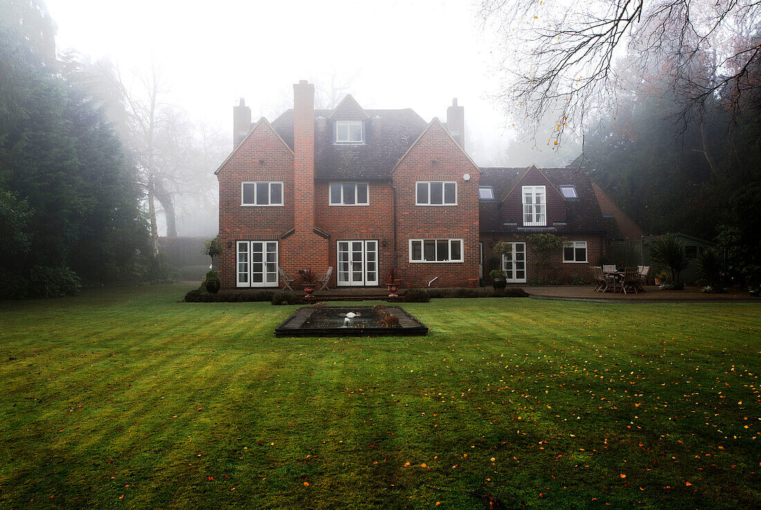Lawned exterior of Chobham home in mist   Surrey   England   UK