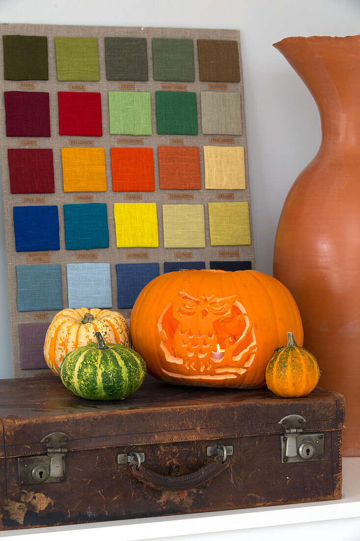 Halloween pumpkin and fabric samples with vintage suitcase in London home,  England,  UK