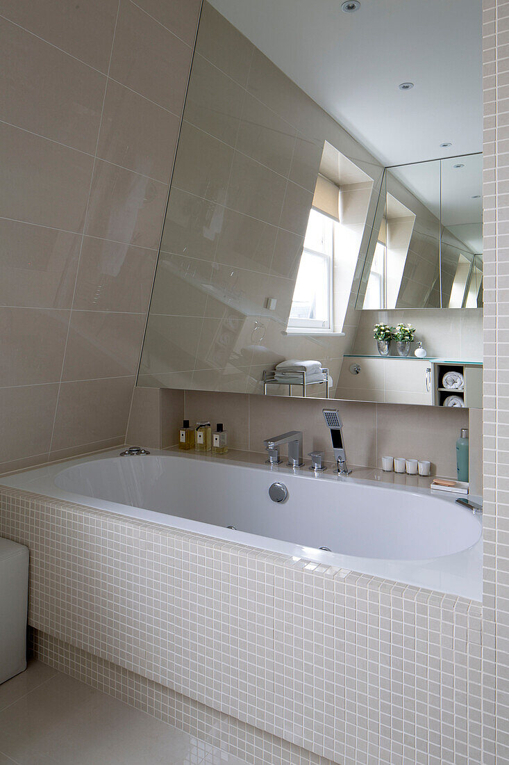Mit Mosaik gefliestes Badezimmer mit Spiegel in einer modernen Londoner Wohnung UK