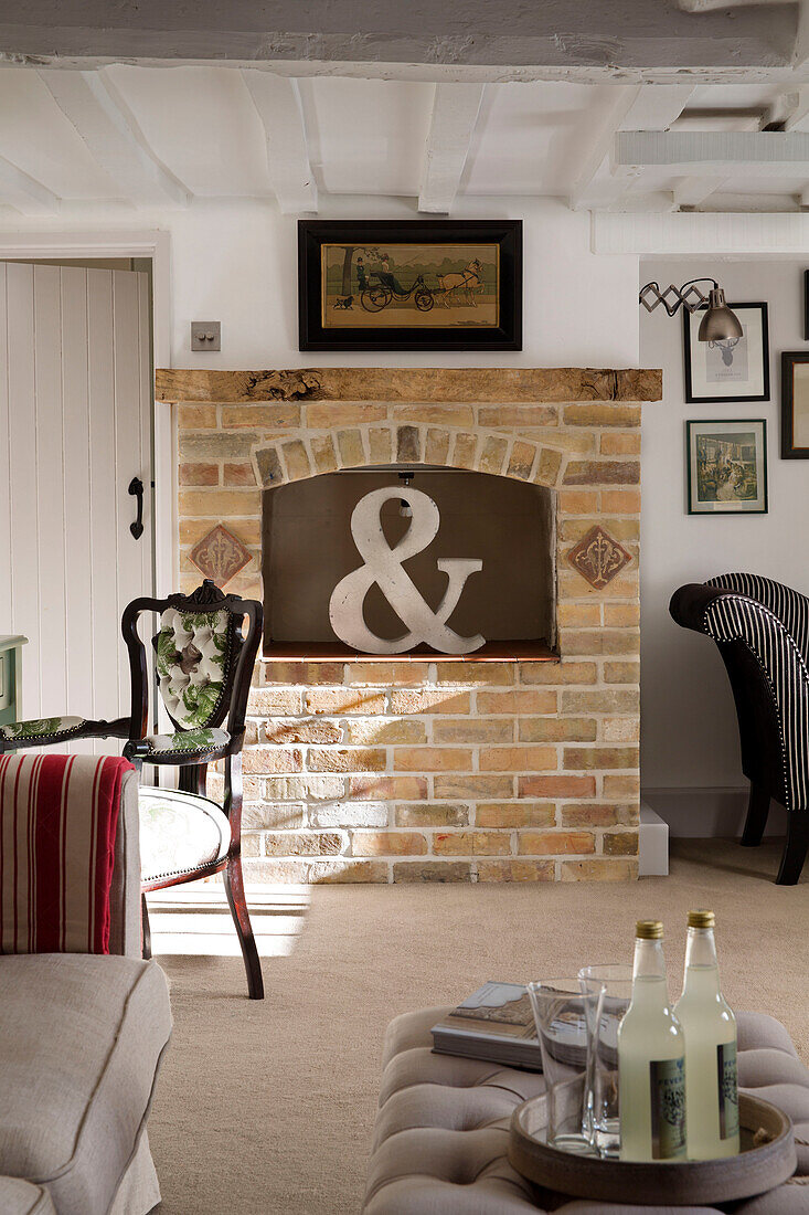 Large ampersand in brick fireplace of sunlit London home,  England,  UK
