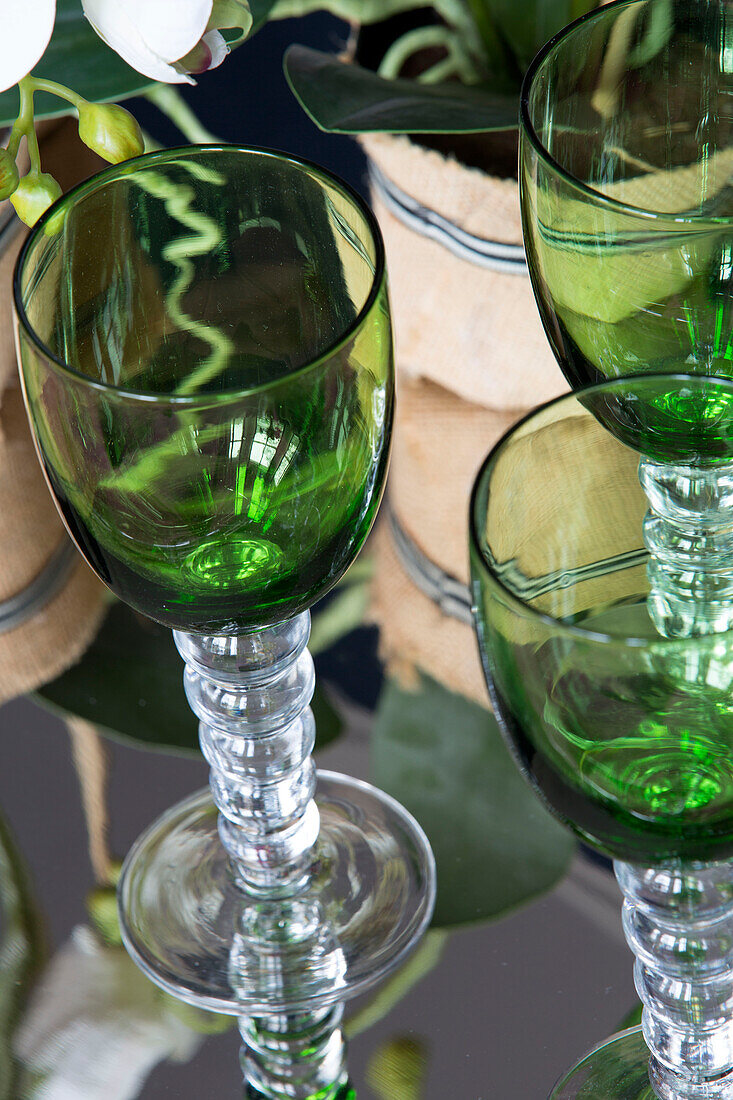 Grüne Glaswaren auf verspiegelter Tischplatte in einer Wohnung in London, England, UK
