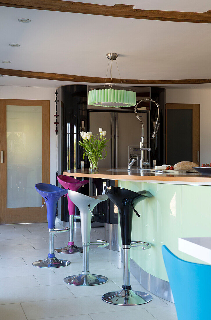 Bunte Barhocker an Kücheninsel mit Spritzwasserhahn in Sandhurst Landhaus Kent England UK