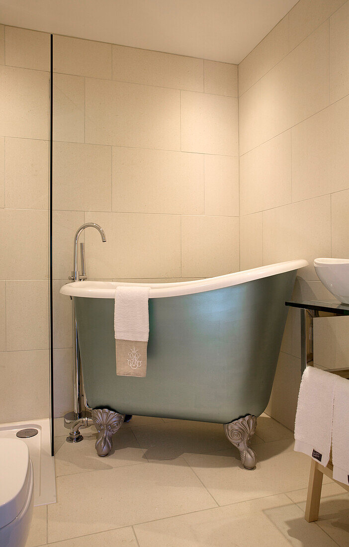 Metallic freestanding bath in cream tiled Sandhurst bathroom  Kent  England  UK