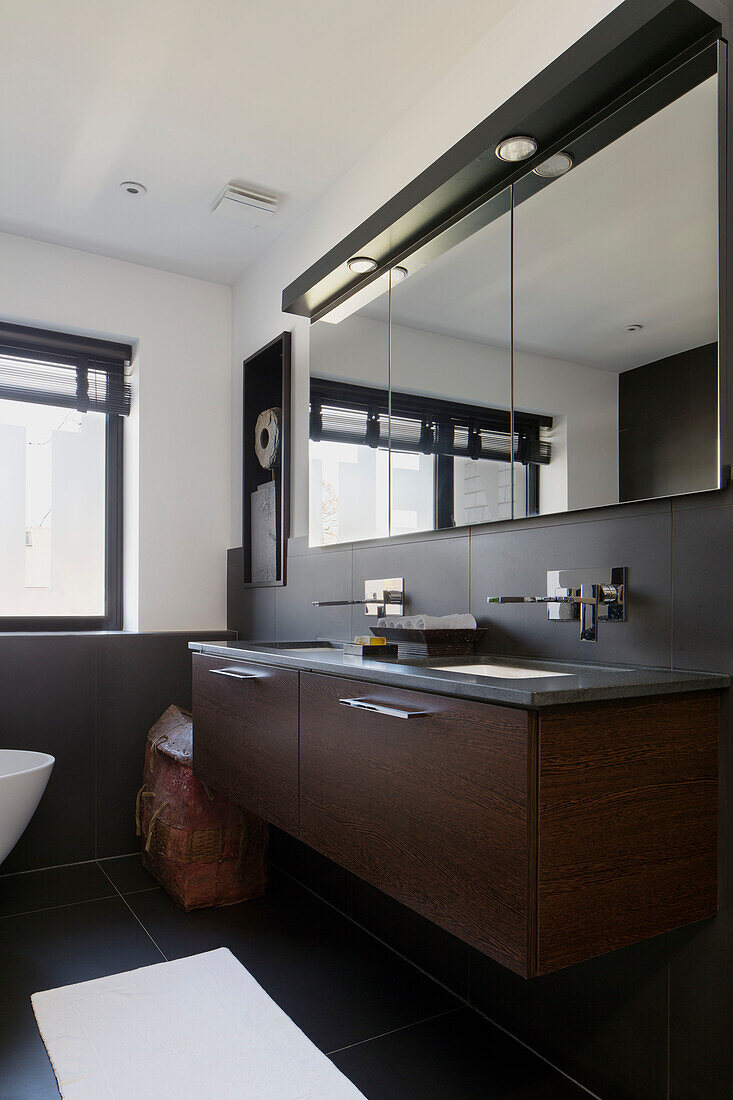 Double wash basins with mirrored cabinets in London home,  England,  UK