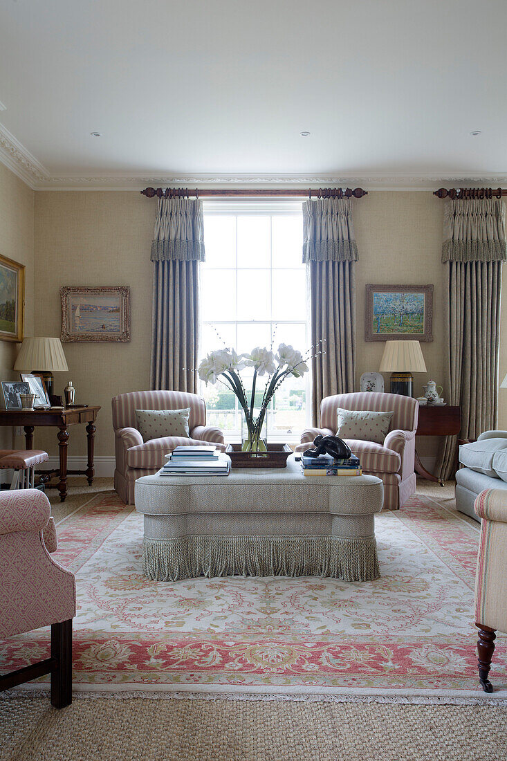 Hellrosa und graue Möbel mit Fransenhocker im Wohnzimmer in Pewsey, Wiltshire, England, Vereinigtes Königreich