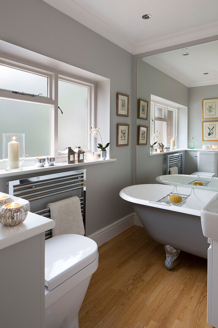 Grey freestanding roll-top bath with mirrored wall in Chobham home   Surrey   England   UK