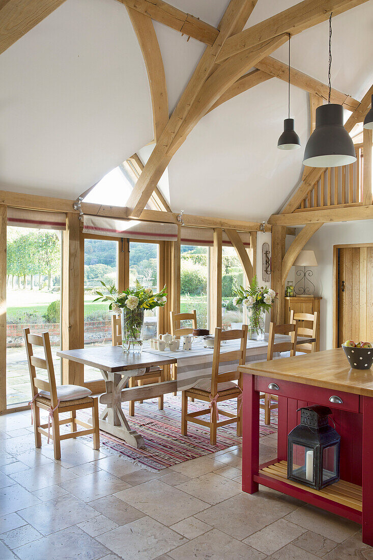 Offene Küche mit Holzbalkendecke und Tisch in einem Bauernhaus in Sussex England UK