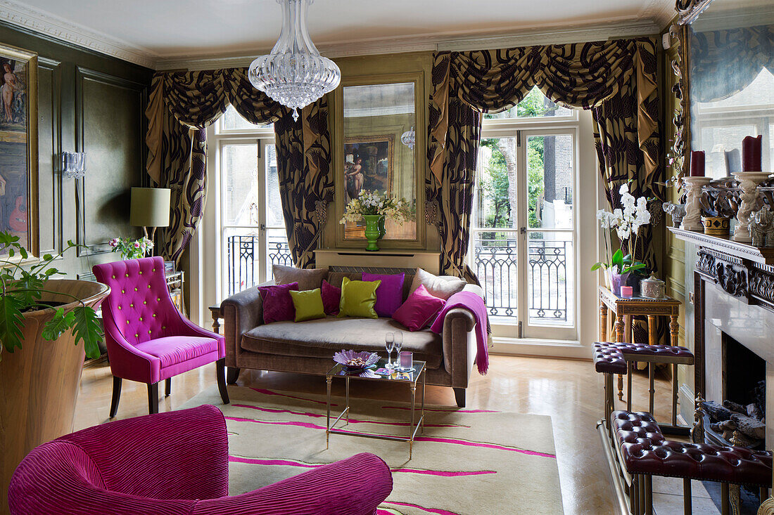 Üppige Vorhänge und rosa Stühle und Kissen im Wohnzimmer eines Londoner Stadthauses England UK