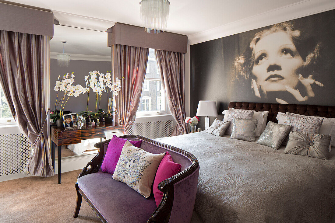 Schwarzer und weißer Druck über einem Kingsize-Bett mit rosa Seidenvorhängen in einem Londoner Stadthaus in England UK