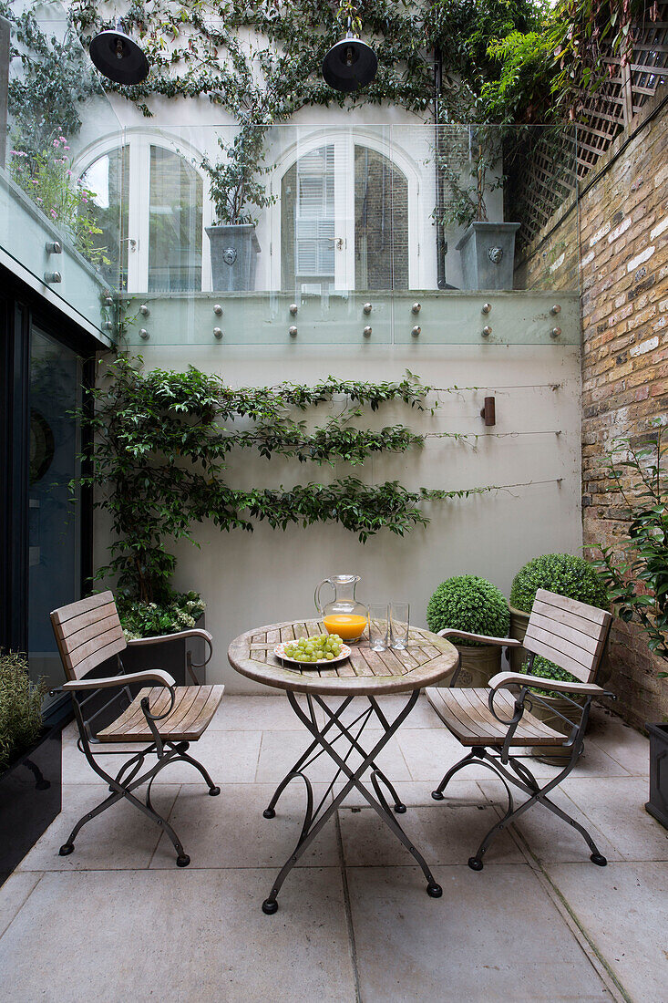Tisch und Stühle im privaten Innenhof eines Londoner Stadthauses England UK