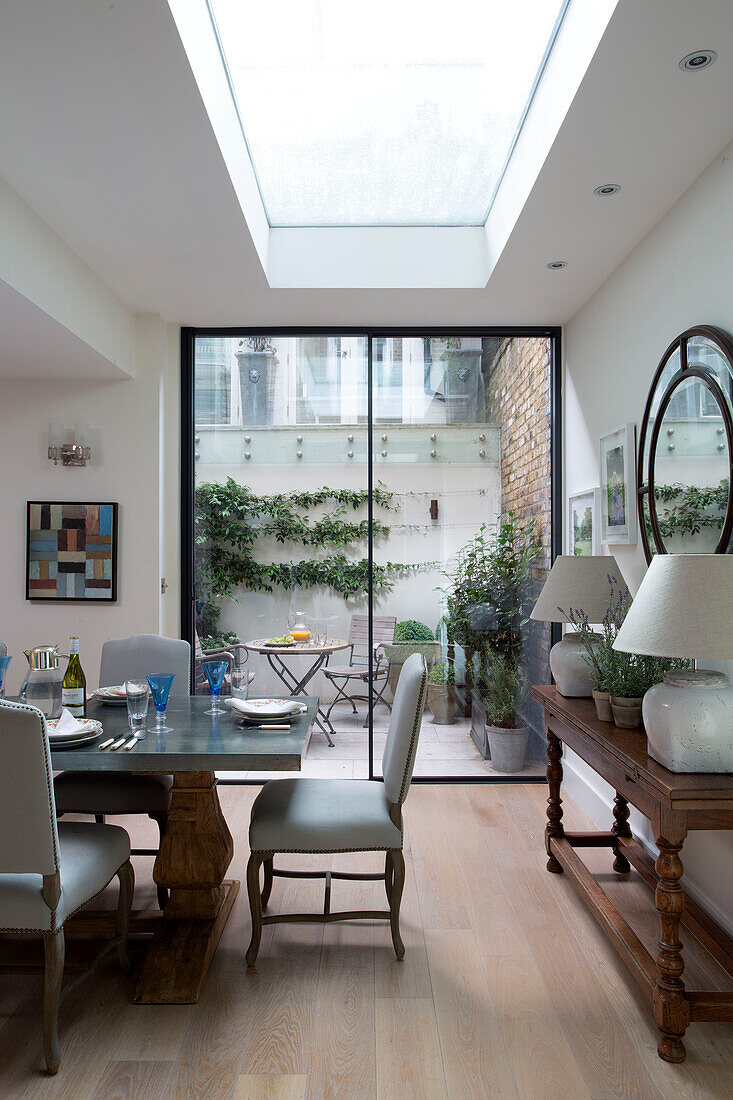 Dining table with view to courtyard garden in kitchen extension of London townhouse   England   UK