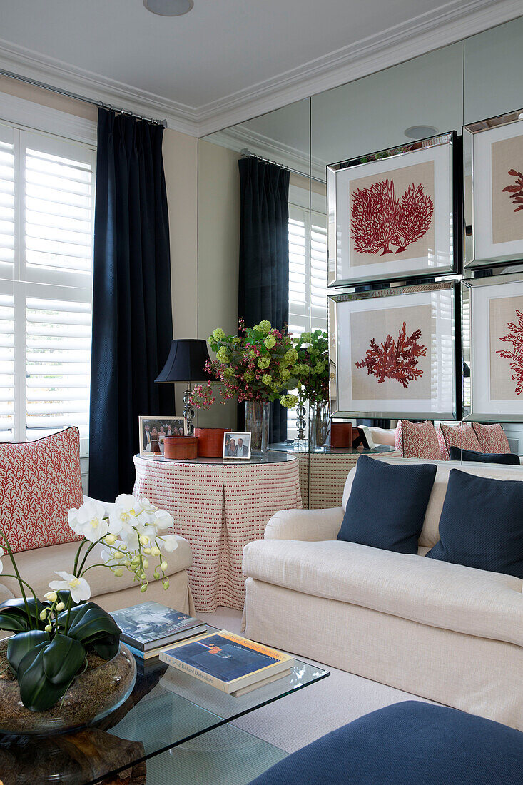 Artwork on mirrored wall with blue cushions and curtains in London townhouse   England   UK
