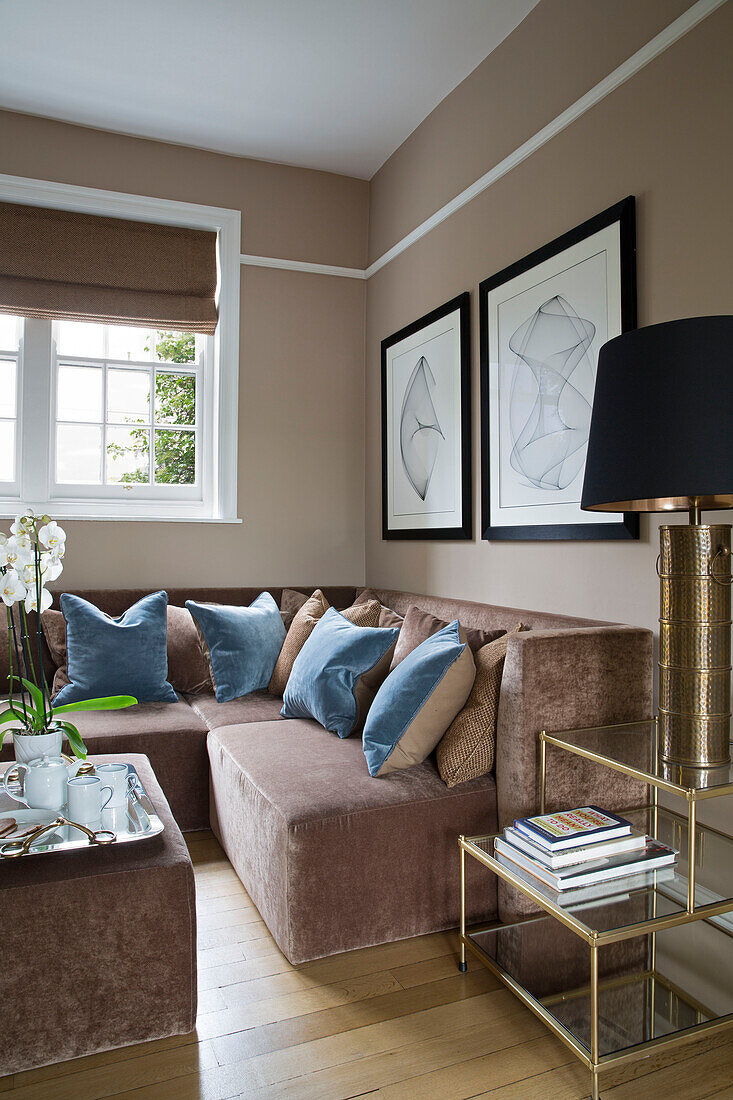 Schwarzer Lampenschirm mit blauen Samtkissen auf braunem Sofa in Londoner Stadthaus England UK