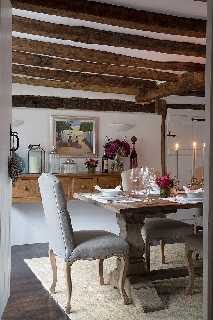 Hellgrauer Esszimmerstuhl am Tisch mit Kerzenlicht in einem Haus in Surrey, England UK