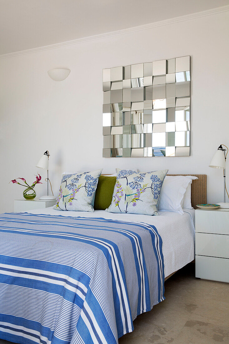 Blue and white striped cover on double bed below mirror in Greek villa Ithaca