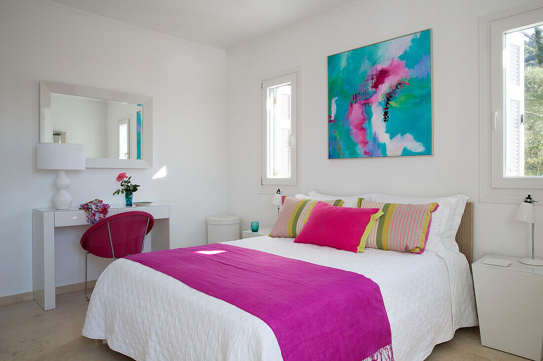 Leuchtend rosa Decke auf einem Doppelbett unter einem modernen Kunstwerk in einer griechischen Villa auf der Insel Ithaka