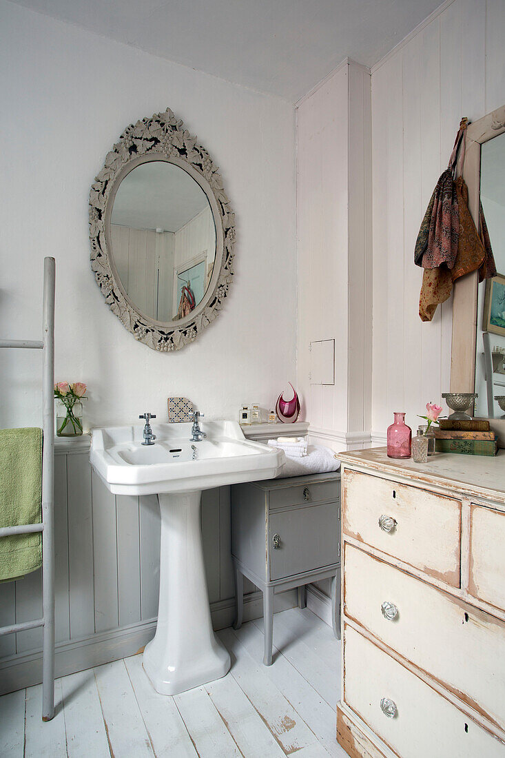 Dekorativer Spiegel über einem Sockelwaschbecken mit Kommode in einem Haus in Norfolk, England, UK