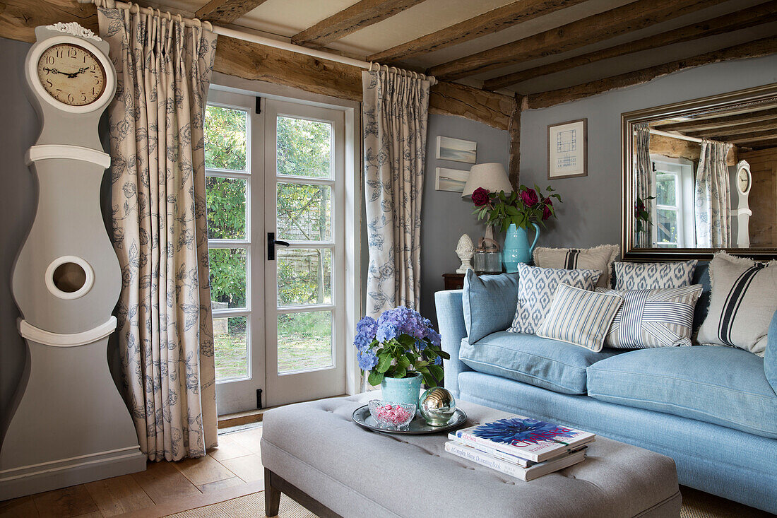 Hellblaues Sofa und Standuhr im Wohnzimmer eines Landhauses in Wokingham, Berkshire UK
