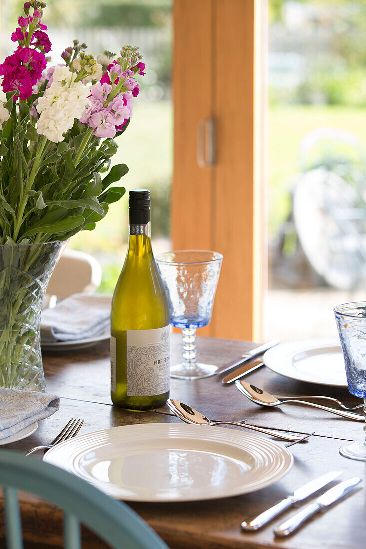White wine and glasses at place setting on Surrey dining table England UK