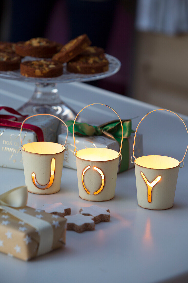 "Kerzenständer mit dem Schriftzug JOY"" und Keksen und Geschenken in einem Haus in Sussex, England, UK"""