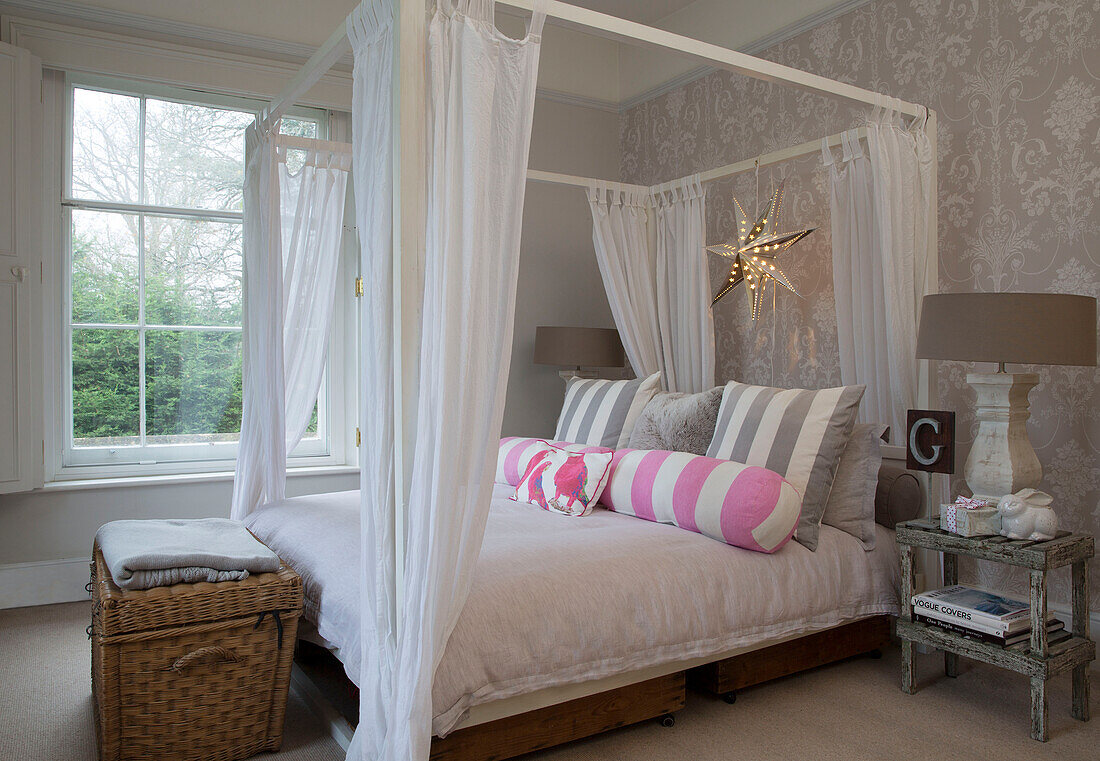 Himmelbett mit Moskitonetz und Decke in einem Haus in Surrey, England UK