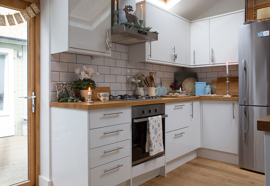Weiße Einbauküche mit silbernem Kühlschrank in einer Wohnung in London, England, UK