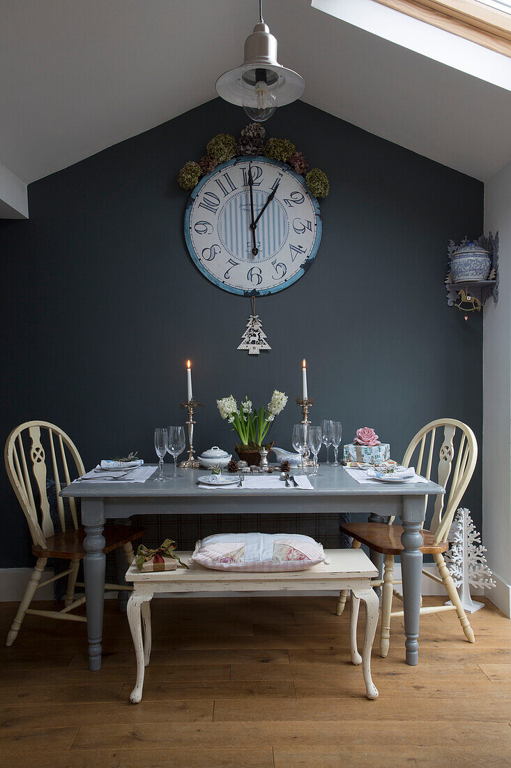 Große Uhr über einem grauen Tisch mit brennenden Kerzen in einem Londoner Haus in England UK