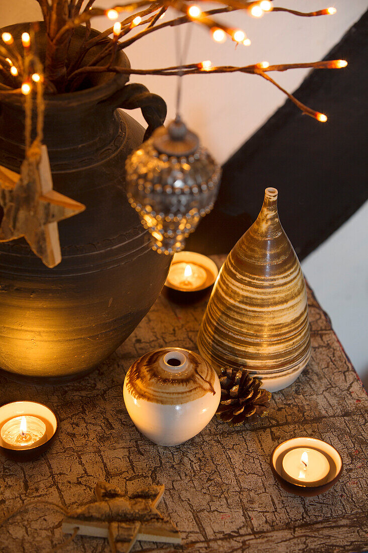 Keramiktöpfe mit brennenden Kerzen auf einer Tischplatte in einem Haus in Kent England UK