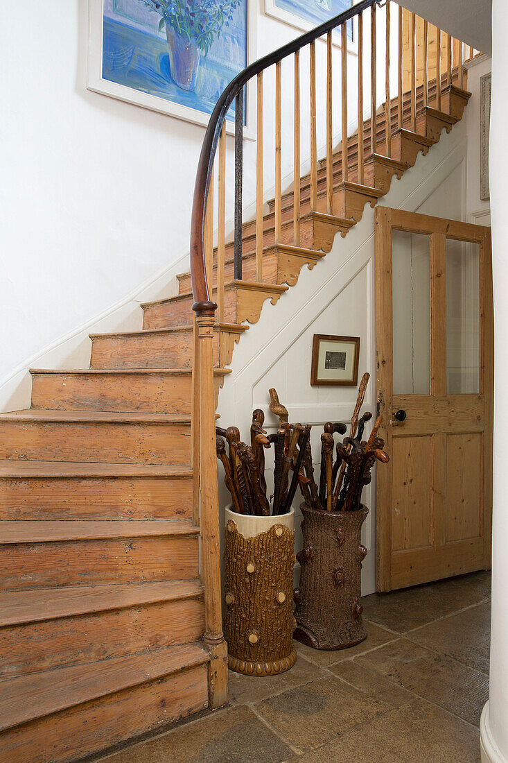 Walking sticks below wooden staircase in Arundel home West Sussex England UK
