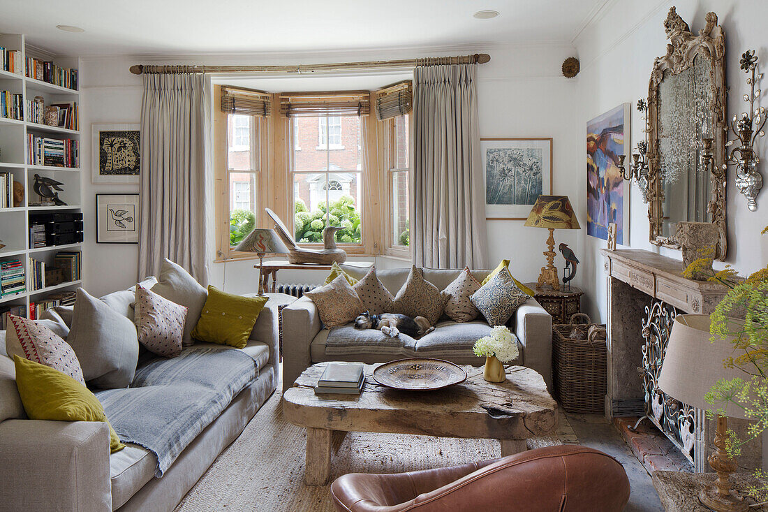 Couchtisch aus Holz mit Sofas und Bücherregal im Wohnzimmer eines Hauses in Arundel, West Sussex, England UK