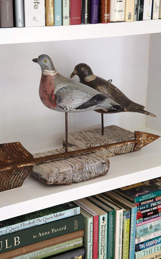 Vogelfiguren und Bücher in einem Regal in Arundel, West Sussex, England UK