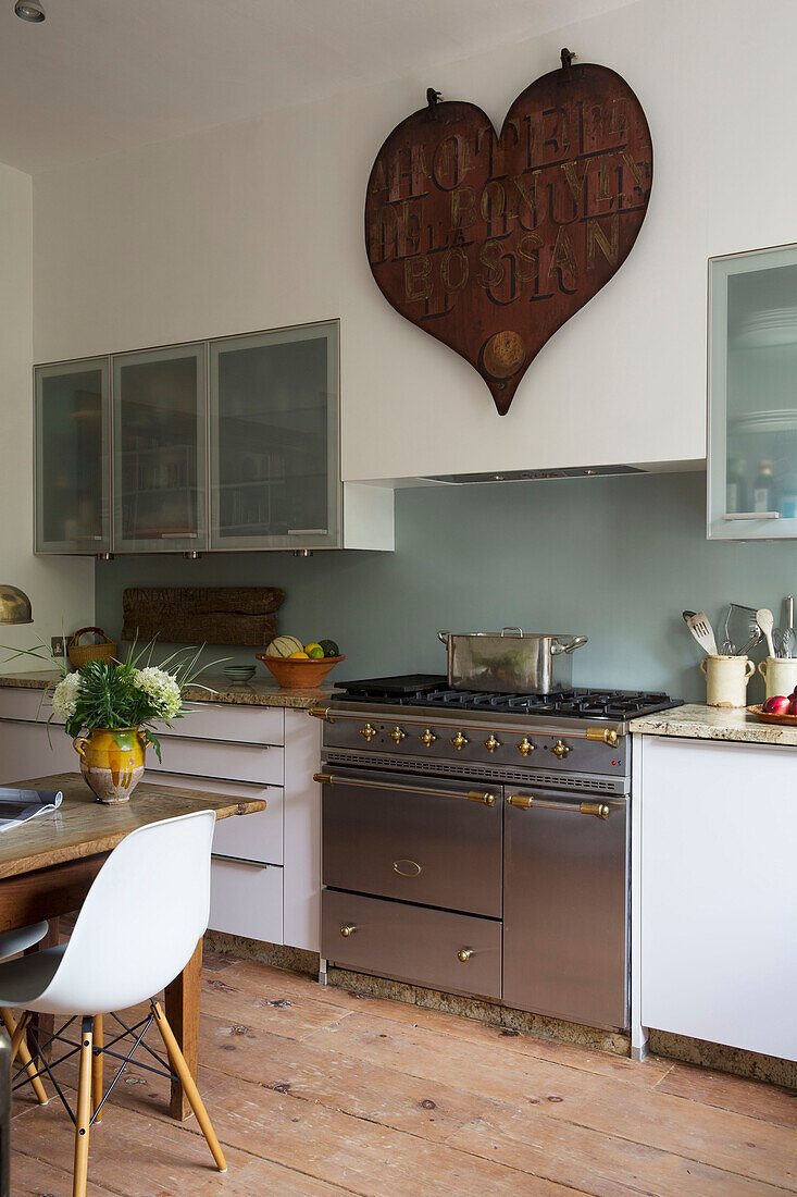 Großes Herz über einem Herd aus Edelstahl in der Küche eines Hauses in Arundel, West Sussex, England