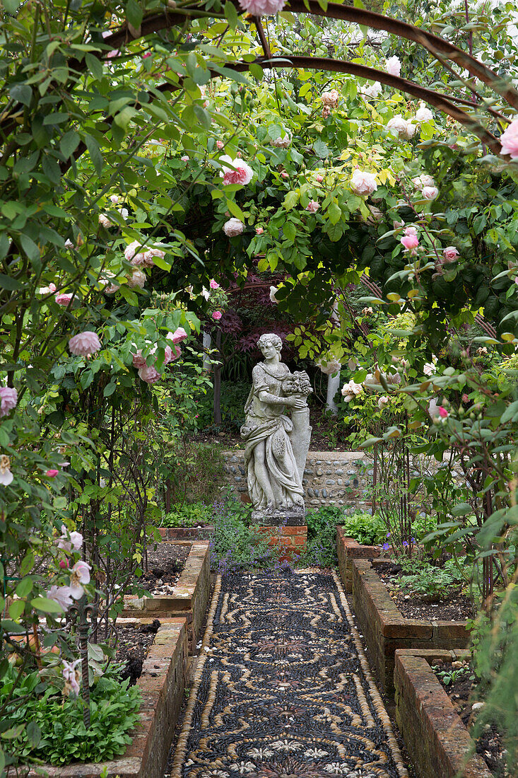 Weibliche Statue mit Blick durch eine Pergola im Parterre-Garten Arundel West Sussex England UK
