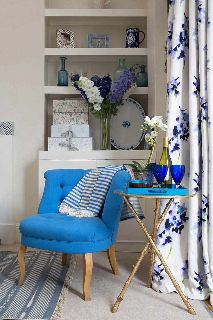 bright buttoned chair with side table and shelves in London townhouse UK