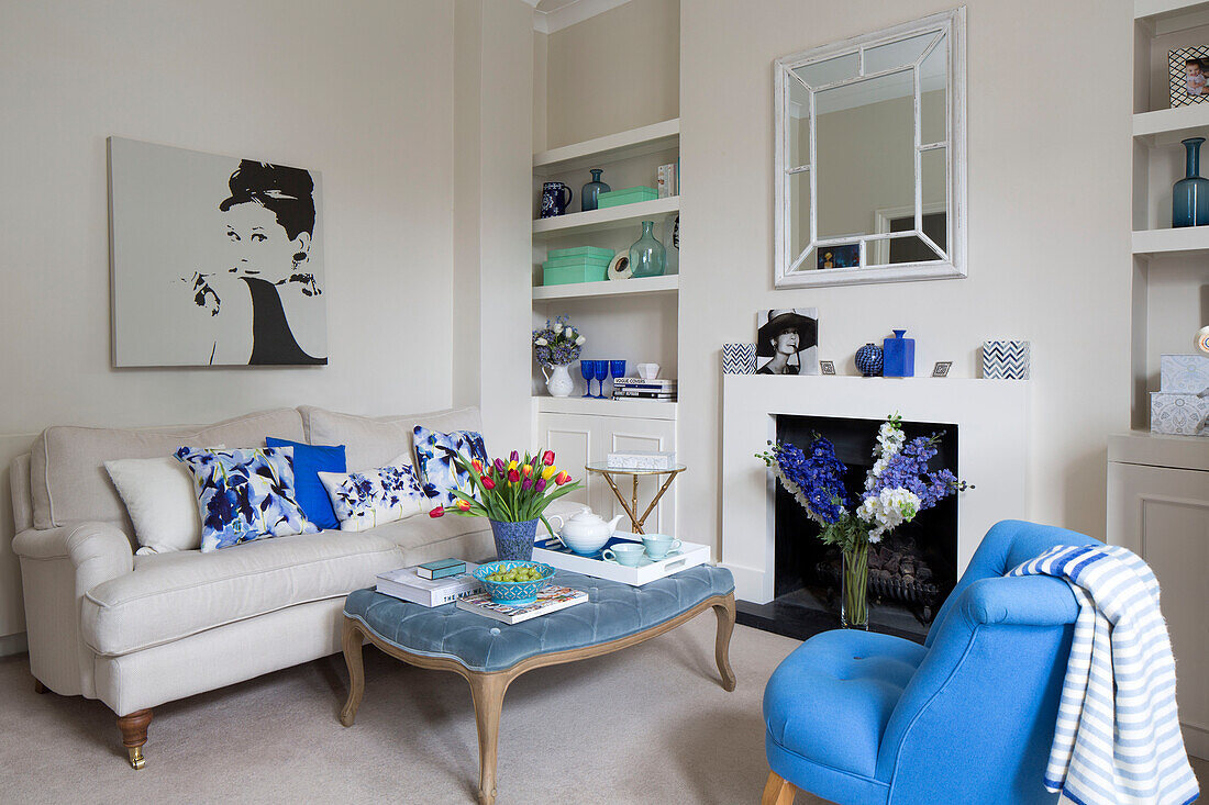Geschnittene Tulpen auf Ottomane mit Sofa und Leinwand von Audrey Hepburn in einem Londoner Stadthaus UK