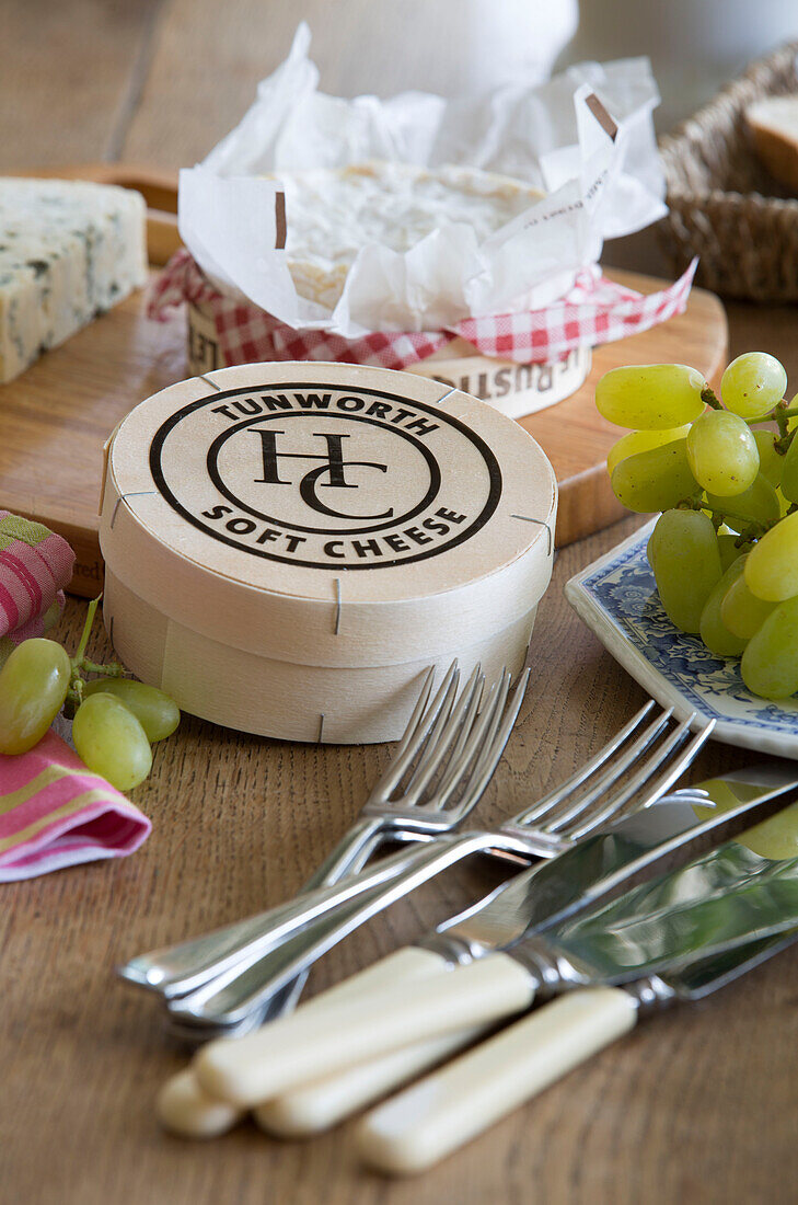 Käse und Weintrauben mit Besteck in einem unter Denkmalschutz stehenden Cottage in Hampshire, England, UK